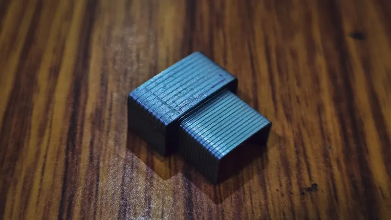 A 3d-printed object sits on a wooden surface.